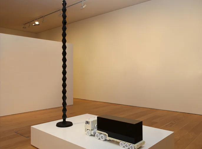 photo of lorry container in front of Brâncuși style endless column